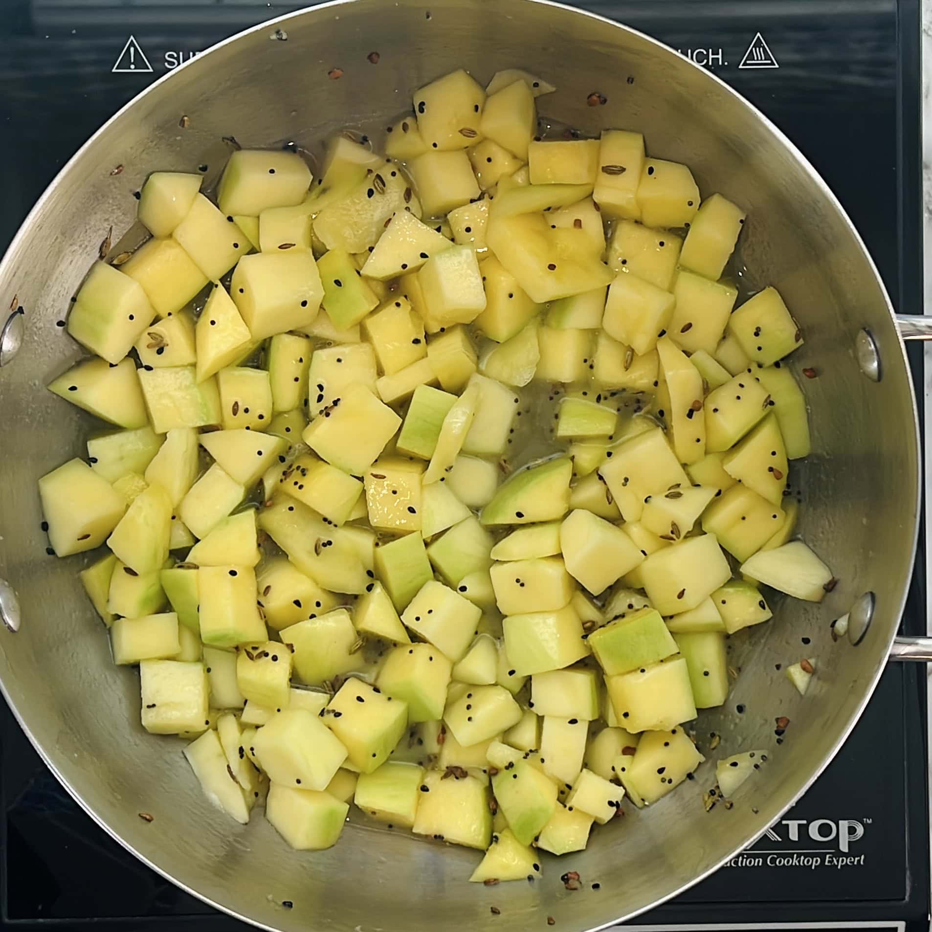diced mangoes added to tempering.