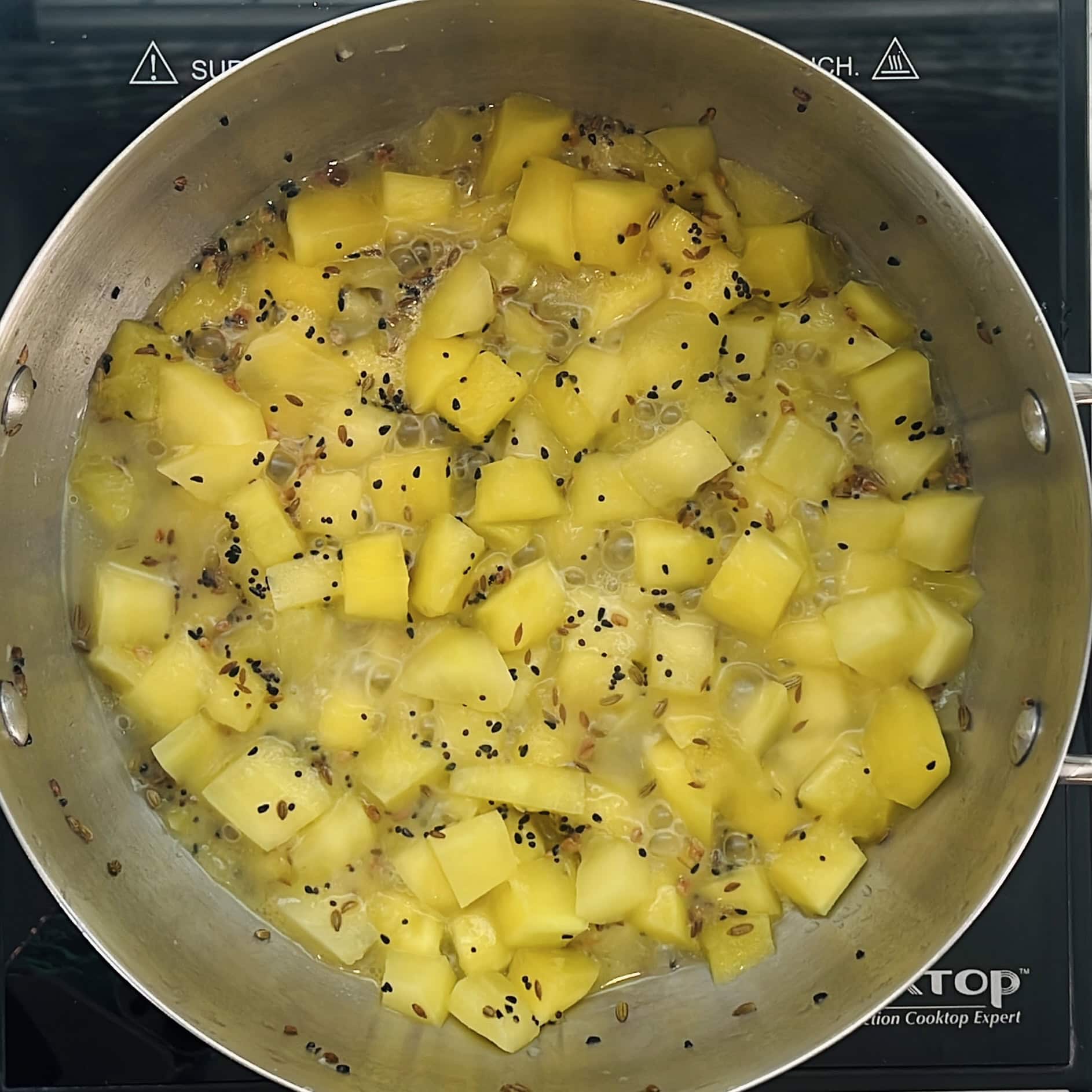 mangoes cooked with tempering n the pan.