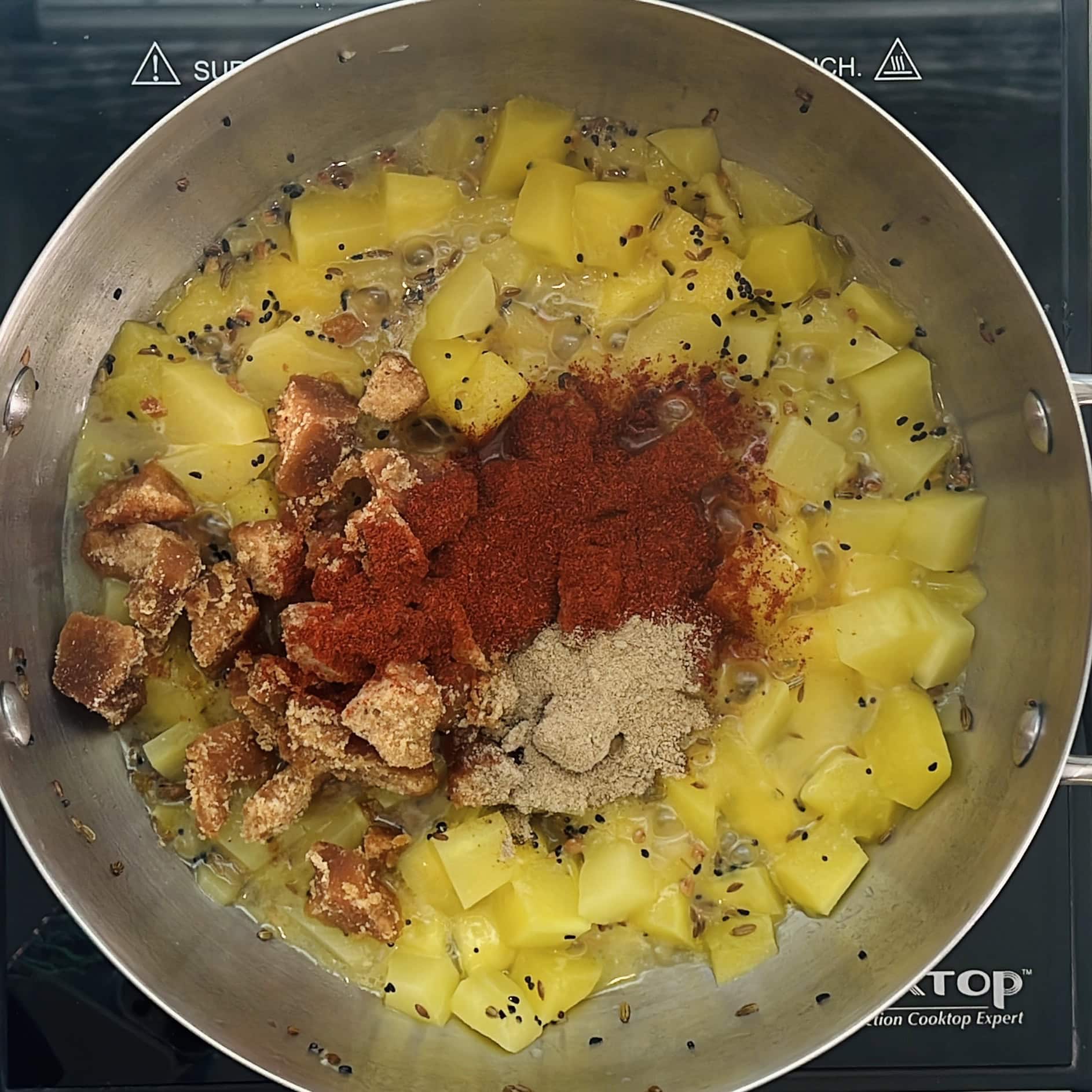 jaggery, red chili powder and chaat masala added to cooked mangoes. 