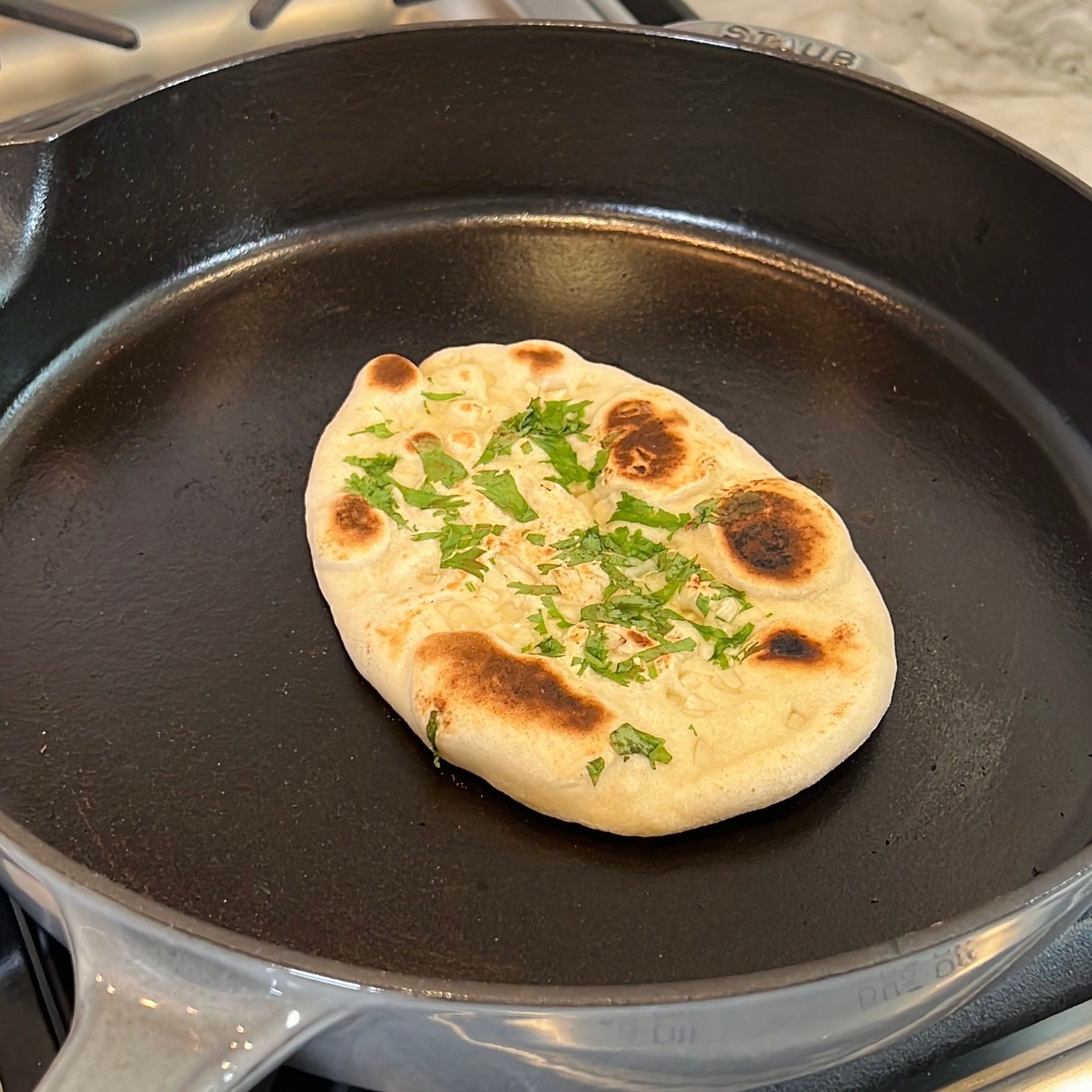 cooked naan on a cast iron skillet