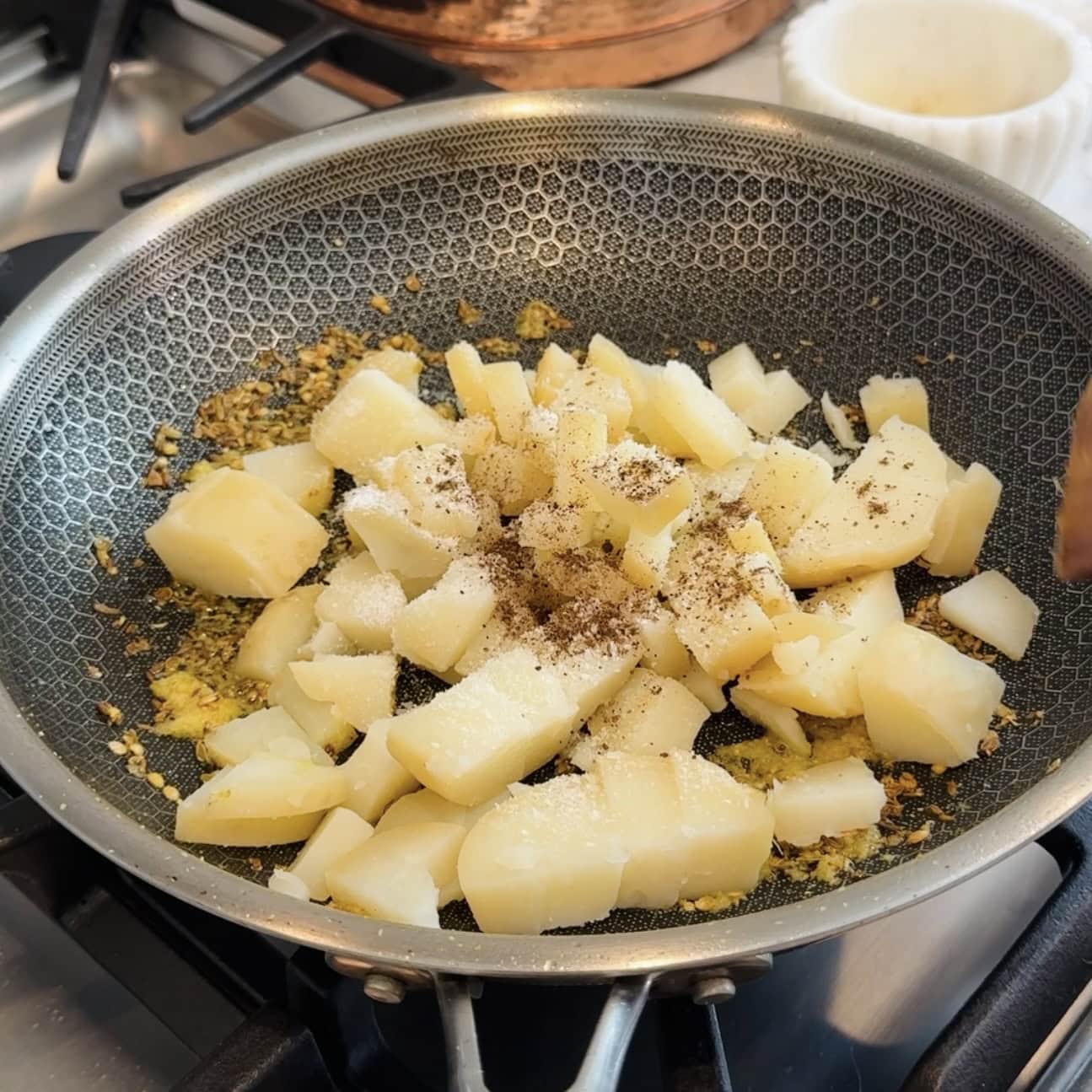 steamed and chopped potatoes added to the pan.