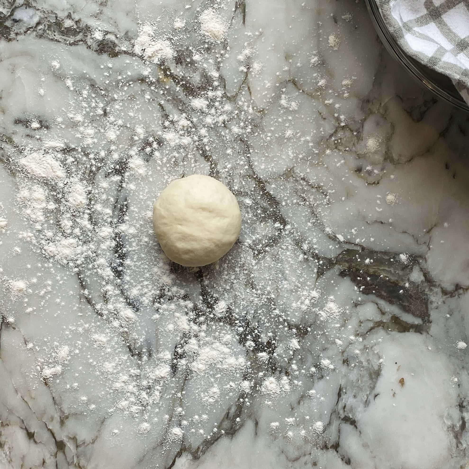 naan dough on flour coated surface