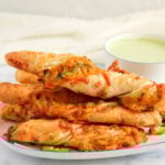 stacked Jalapeño Cheese Samosa Twists on a platter.