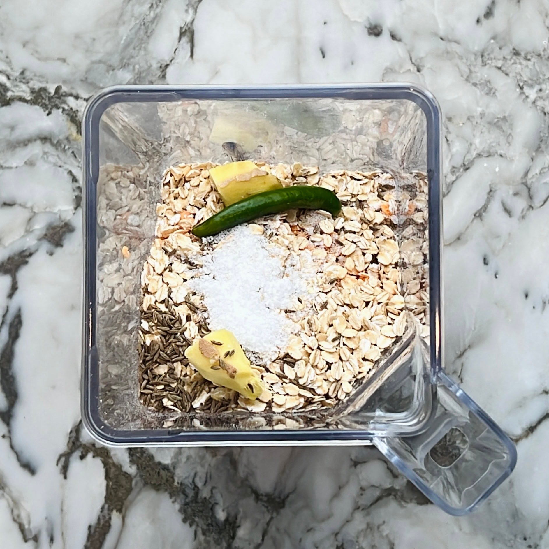 cumin seeds, ginger, green chili, oats and salt added to blender jar.