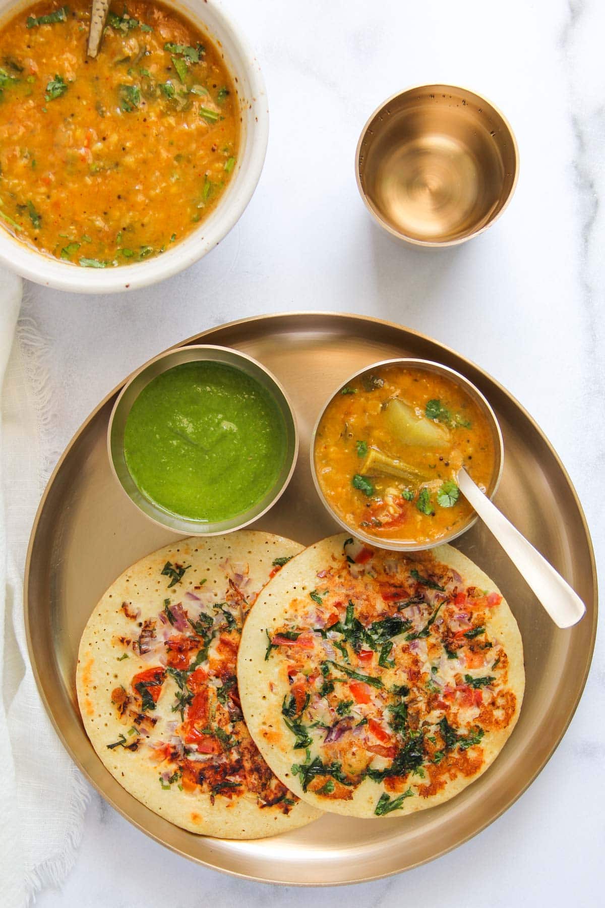 Uttapam served with sambar and chutney.